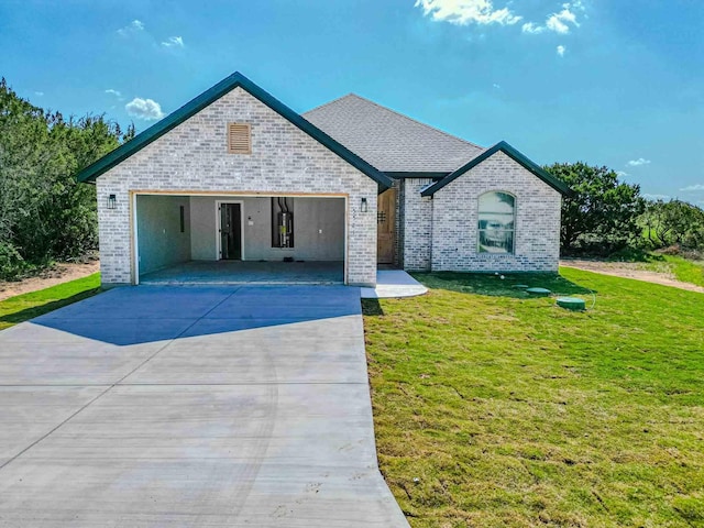 view of front of property with brick siding, a garage, driveway, and a front yard