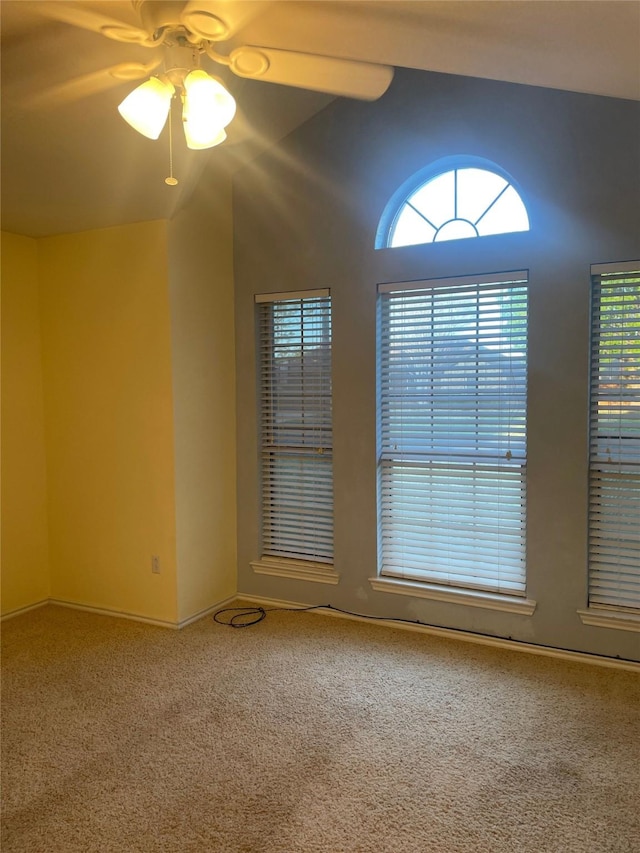 carpeted spare room with baseboards and a ceiling fan