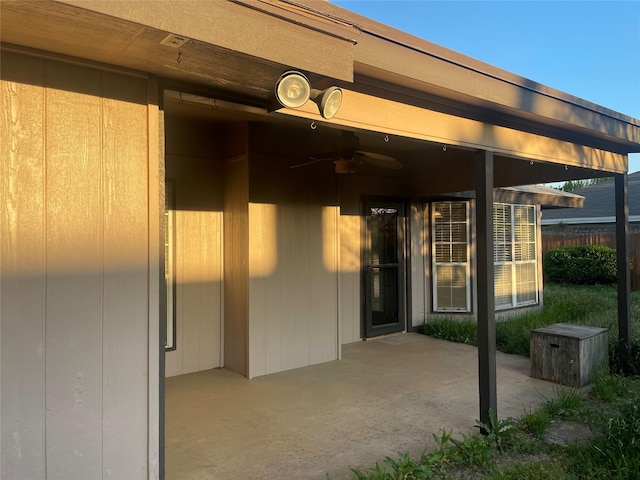 property entrance with fence, a ceiling fan, and a patio area