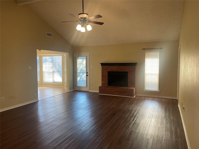 unfurnished living room featuring visible vents, dark wood-type flooring, ceiling fan, and a healthy amount of sunlight