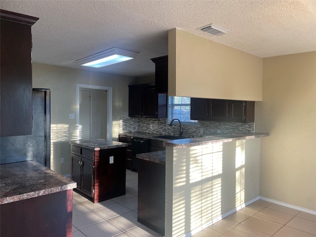 kitchen featuring a sink, a center island, backsplash, and visible vents