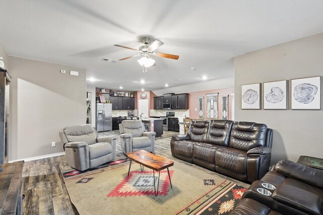 living area featuring ceiling fan, visible vents, wood finished floors, baseboards, and recessed lighting