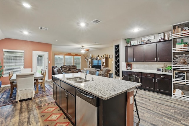 kitchen with a sink, visible vents, wood finished floors, and dishwasher