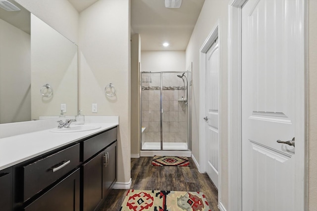 full bath with vanity, recessed lighting, baseboards, a shower stall, and wood finished floors