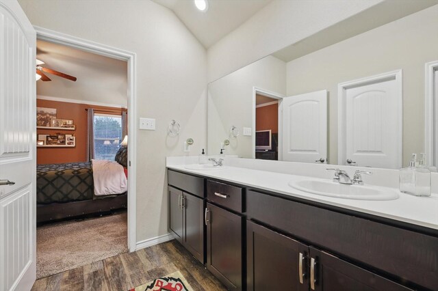 ensuite bathroom with double vanity, a sink, wood finished floors, and ensuite bath