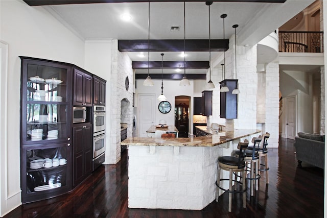 320 Hines Xing, Bullard, TX 75757 - kitchen featuring light stone countertops, arched walkways, decorative columns, a kitchen bar, and dark wood-style floors