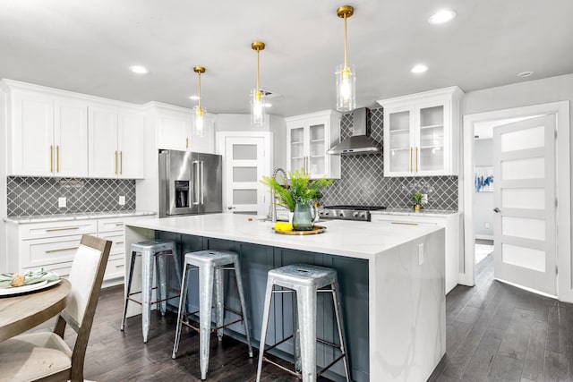 8911 Diceman Dr, Dallas, TX 75218 - kitchen featuring decorative backsplash, stainless steel appliances, dark wood finished floors, and wall chimney exhaust hood