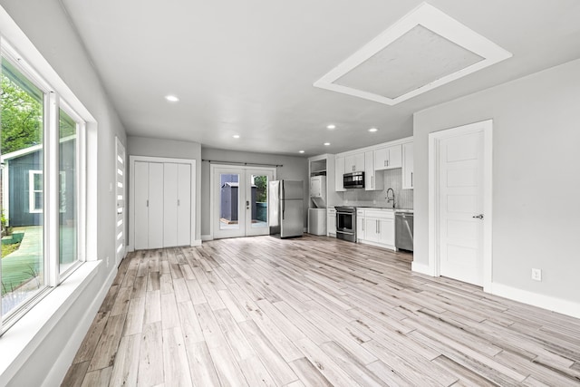 8911 Diceman Dr, Dallas, TX 75218 - unfurnished living room with french doors, recessed lighting, a sink, and light wood-style flooring