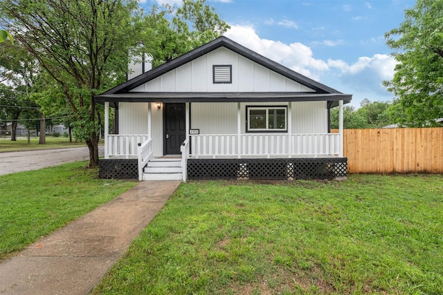 bungalow-style home with a porch, a front lawn, and fence
