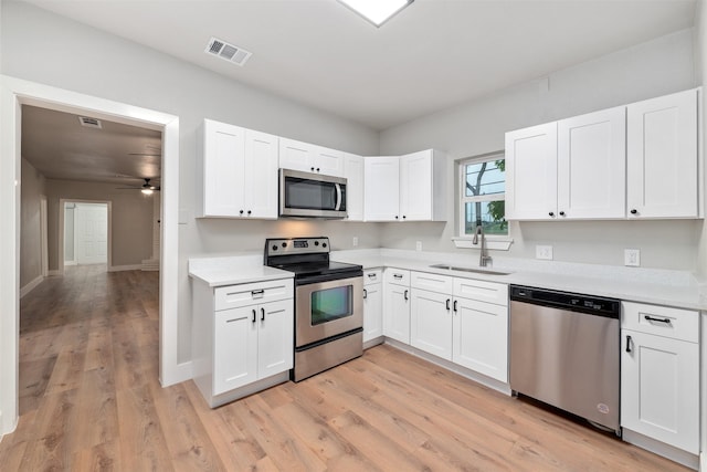 kitchen featuring visible vents, ceiling fan, light countertops, a sink, and stainless steel appliances