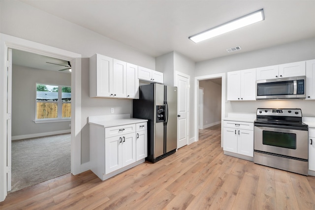 kitchen with light countertops, appliances with stainless steel finishes, white cabinetry, and visible vents