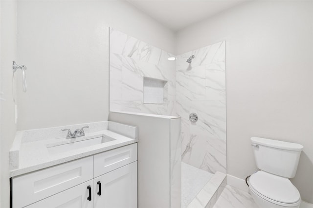 bathroom with toilet, a marble finish shower, marble finish floor, and vanity