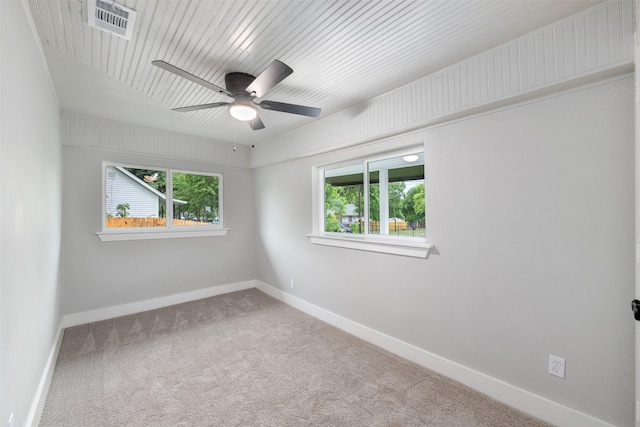 carpeted empty room with visible vents, baseboards, ceiling fan, and a healthy amount of sunlight