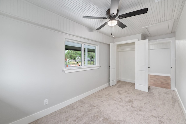 unfurnished bedroom with a ceiling fan, attic access, baseboards, a closet, and carpet flooring