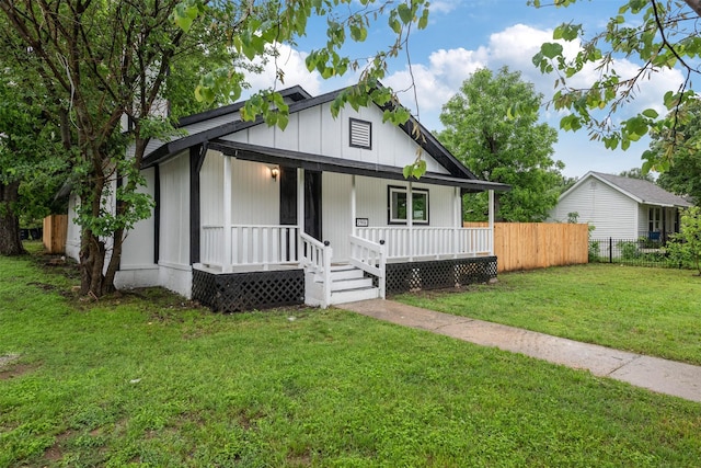 bungalow featuring fence, a porch, and a front yard