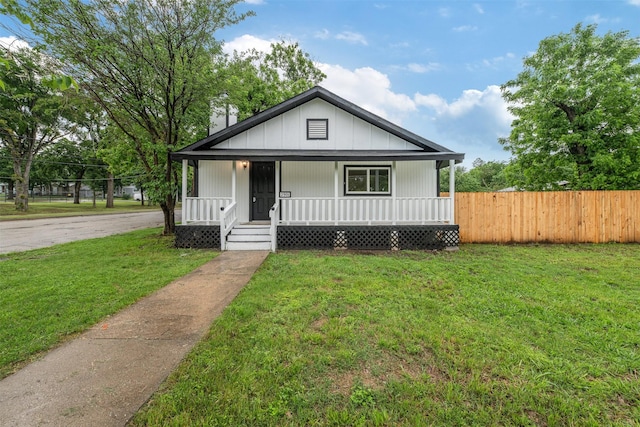 bungalow-style home featuring a porch, fence, and a front yard