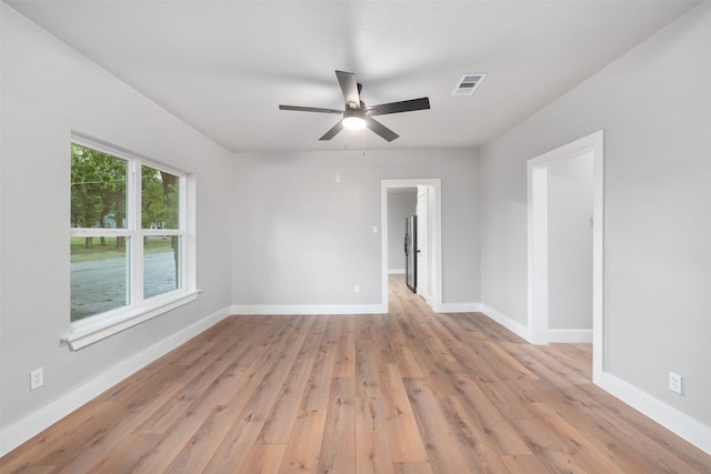 empty room with a ceiling fan, baseboards, visible vents, and light wood-type flooring