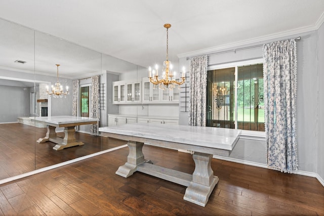 unfurnished dining area featuring baseboards, ornamental molding, dark wood-style floors, and a notable chandelier