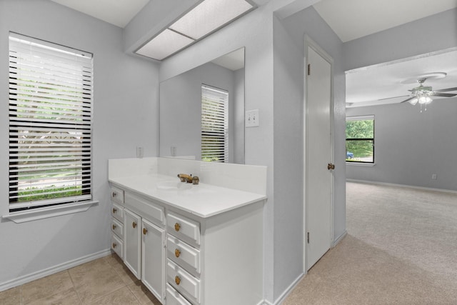 bathroom featuring baseboards, a ceiling fan, and vanity