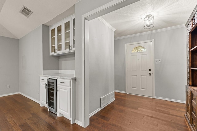 entrance foyer featuring visible vents, dark wood-type flooring, baseboards, and wine cooler
