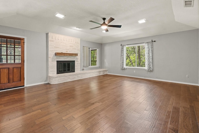 unfurnished living room with baseboards, ceiling fan, visible vents, and dark wood finished floors