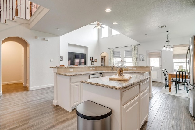9820 Mullins Crossing Dr, Fort Worth, TX 76126 - kitchen featuring a kitchen island, arched walkways, plenty of natural light, a sink, and recessed lighting