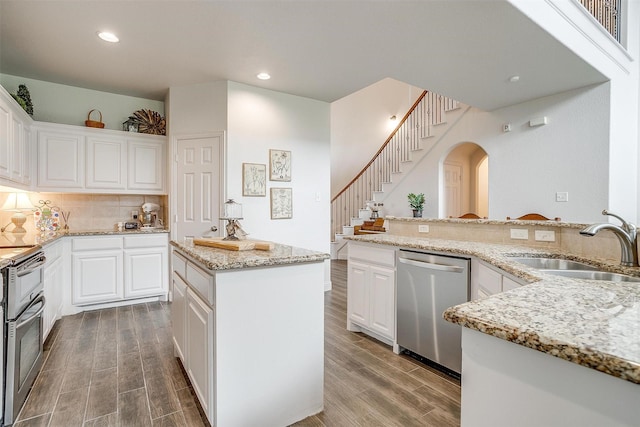 9820 Mullins Crossing Dr, Fort Worth, TX 76126 - kitchen featuring appliances with stainless steel finishes, a sink, wood finished floors, arched walkways, and recessed lighting