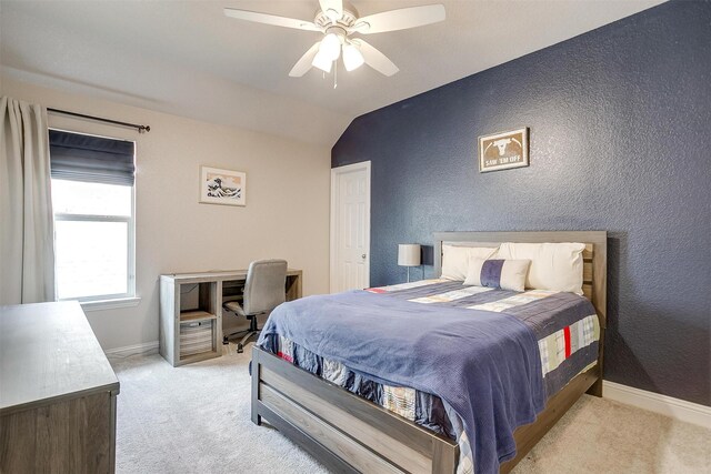 bedroom featuring a textured wall, baseboards, vaulted ceiling, and light carpet