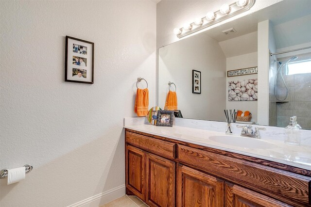 bathroom with vanity, tile patterned flooring, and baseboards