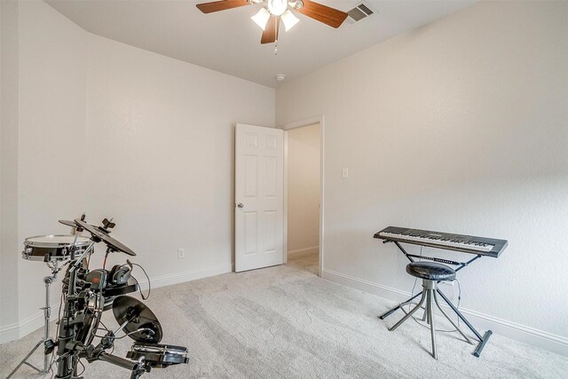 exercise area featuring carpet flooring, ceiling fan, visible vents, and baseboards