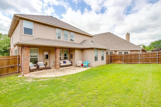 rear view of house featuring a lawn, a patio, an outdoor living space, and a fenced backyard