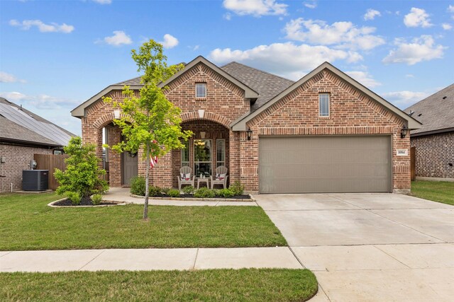 view of front of home featuring an attached garage, a front yard, and brick siding