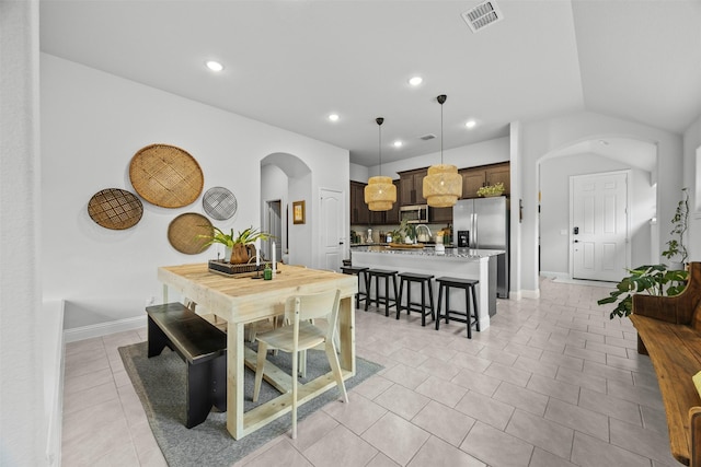 dining area featuring arched walkways, recessed lighting, light tile patterned flooring, and visible vents