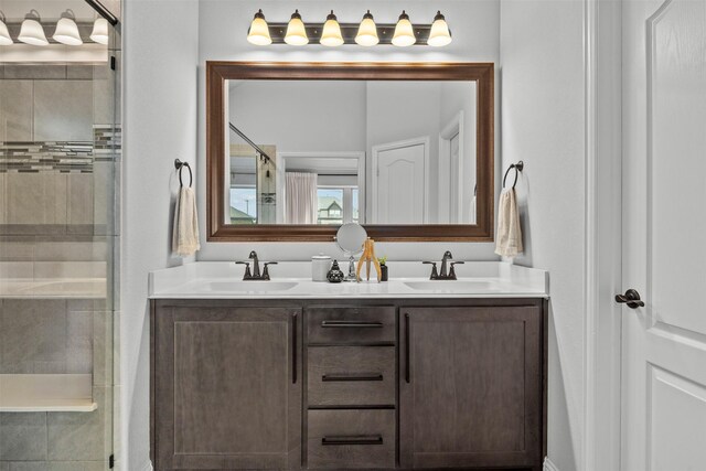 full bathroom with double vanity, a shower stall, and a sink