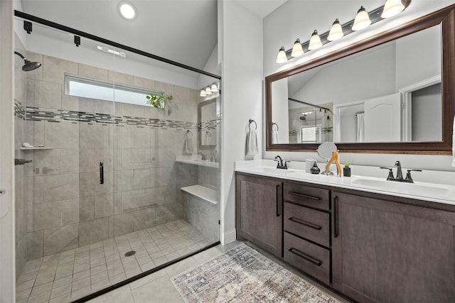 bathroom with double vanity, a sink, a stall shower, and tile patterned flooring