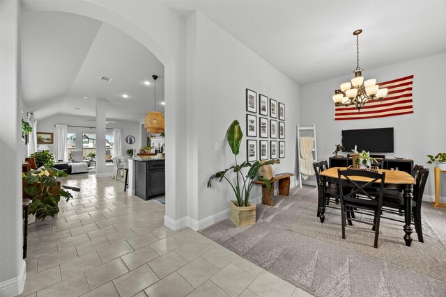 dining space with lofted ceiling, light tile patterned flooring, baseboards, a chandelier, and arched walkways