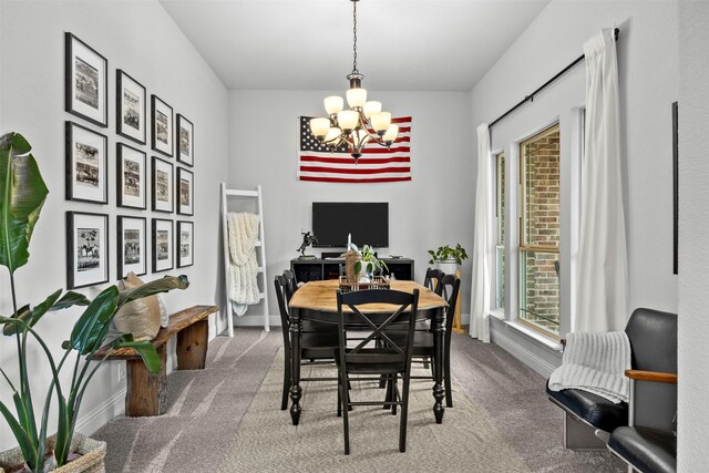dining space with carpet floors, baseboards, and a chandelier
