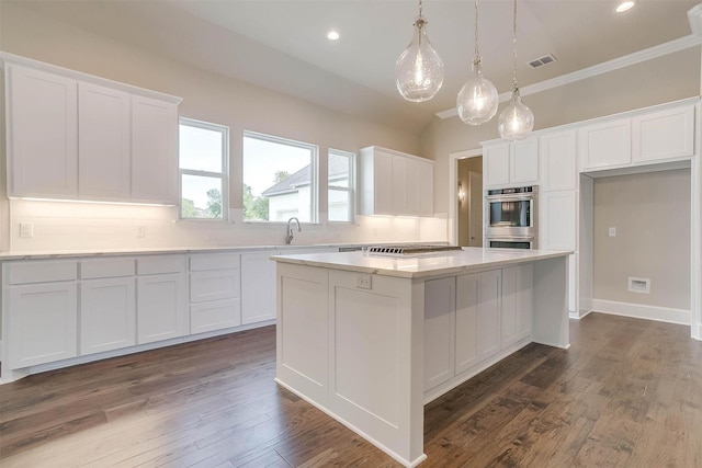 kitchen with a center island, white cabinets, stainless steel appliances, and tasteful backsplash