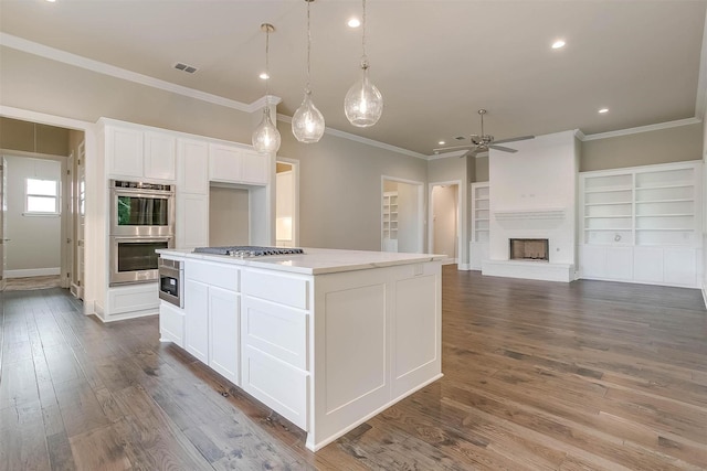 kitchen featuring ceiling fan, dark wood finished floors, stainless steel appliances, white cabinetry, and ornamental molding