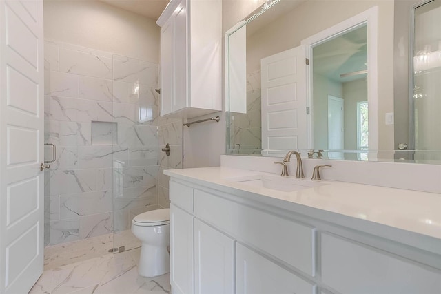 bathroom with vanity, marble finish floor, a marble finish shower, and toilet
