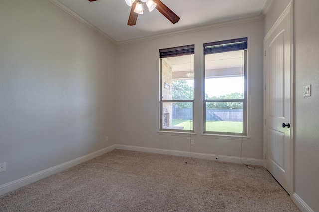 carpeted spare room featuring crown molding, a ceiling fan, and baseboards