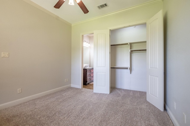 unfurnished bedroom with ceiling fan, visible vents, crown molding, a closet, and carpet flooring