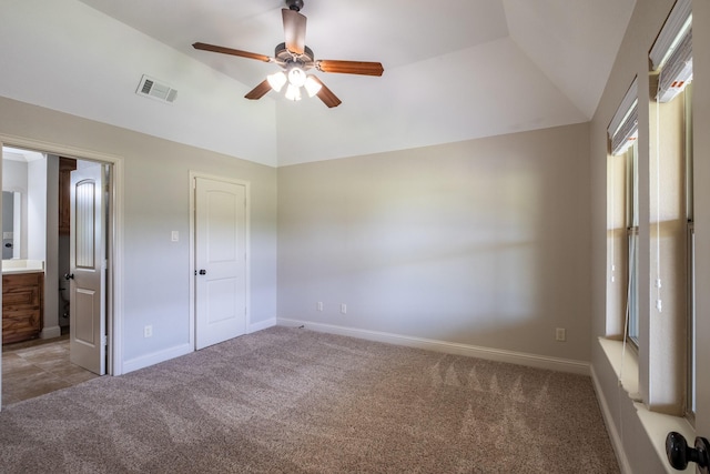 unfurnished bedroom featuring baseboards, visible vents, carpet, and vaulted ceiling