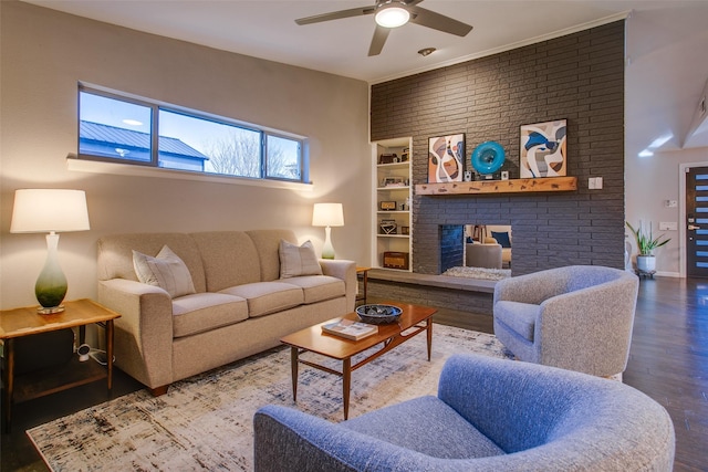 living area with a brick fireplace, built in shelves, a ceiling fan, baseboards, and wood finished floors
