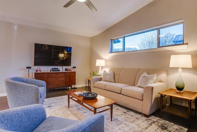 living area featuring a ceiling fan, baseboards, vaulted ceiling, and wood finished floors