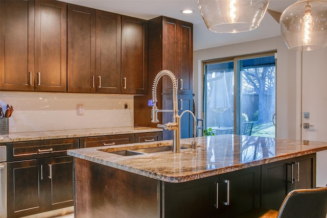 kitchen with a sink, light stone countertops, backsplash, and recessed lighting