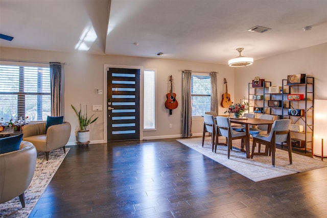 dining space with baseboards, wood finished floors, and visible vents