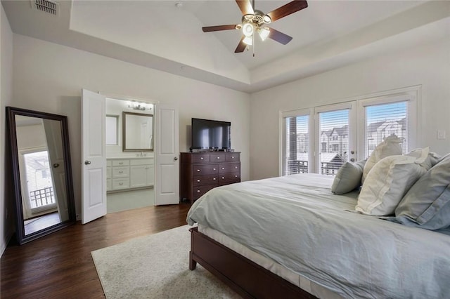 bedroom featuring access to outside, ensuite bath, dark wood finished floors, lofted ceiling, and visible vents