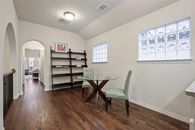 office space with arched walkways, baseboards, dark wood finished floors, and visible vents