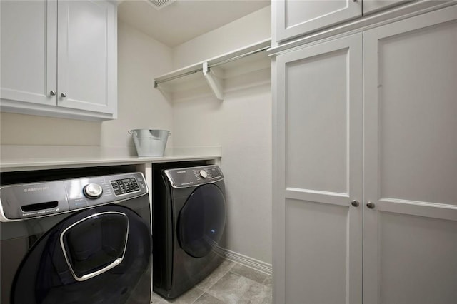 laundry area with cabinet space, baseboards, and washing machine and dryer
